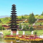 Pura tradisional dengan taman berwarna-warni dan danau tenang, menciptakan suasana damai untuk pengunjung.