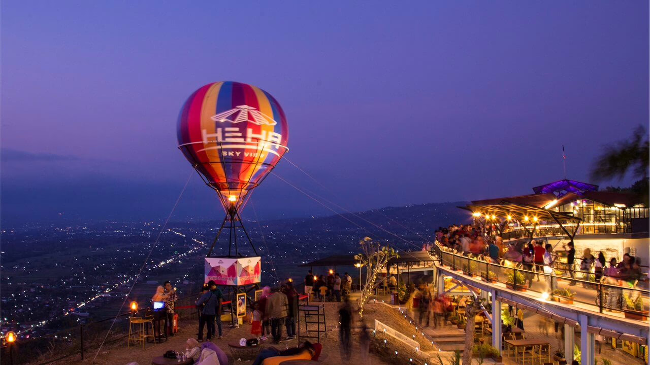 Balon udara panas berwarna-warni "HE HA Sky View" beroperasi di atas pemandangan malam kota yang ramai dan berpendar.