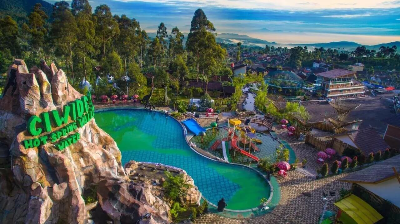 Wisata pemandian air panas Giwide di pegunungan, dikelilingi taman hijau dan berbagai wahana untuk keluarga dan anak-anak.